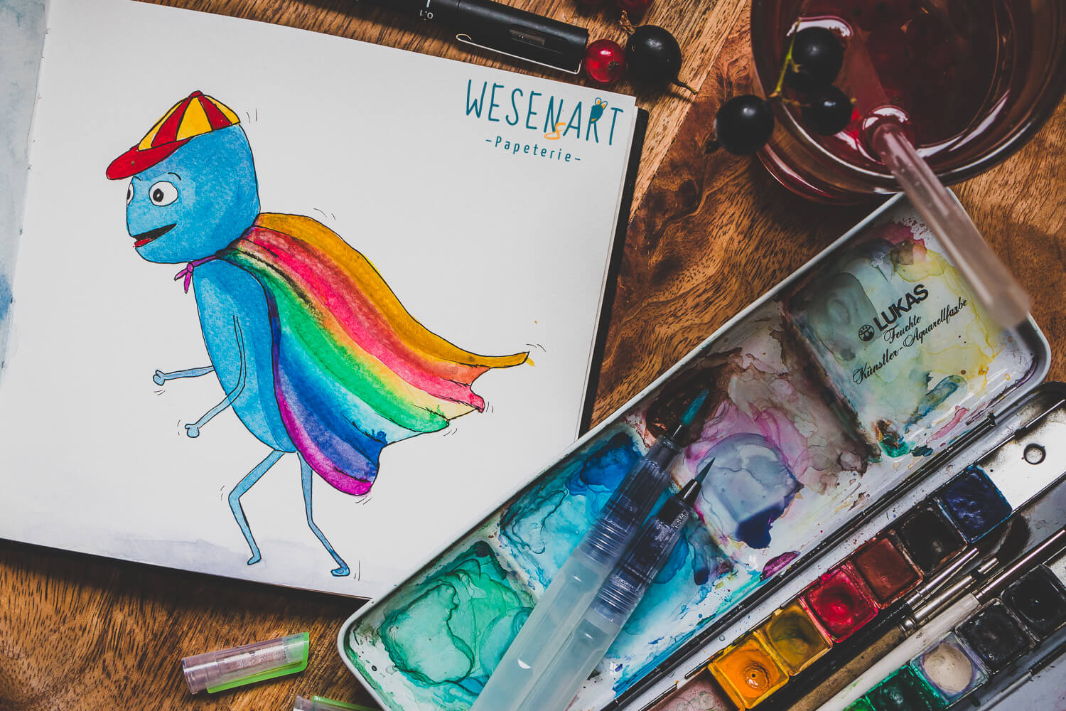 WESENsART – Alex läuft mit einem Regenbogenumhang herum.